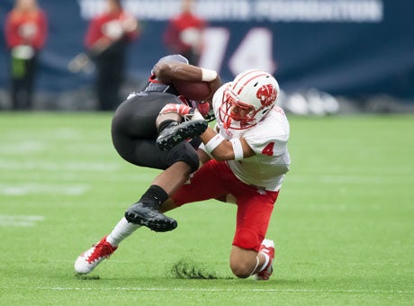 Katy senior defensive back Isaiah Brown lays a big hit during his team's 49-0 win on Friday. Katy held high-powered Langham Creek to 288 yards below its season average. 