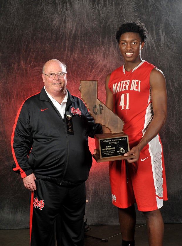 Johnson shares his fourth state title trophy with coach Gary McKnight.
