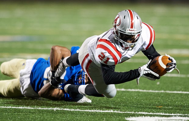 Archer receiver Aramis Bryant stretches for yardage while being tackled by a McEachern defender.