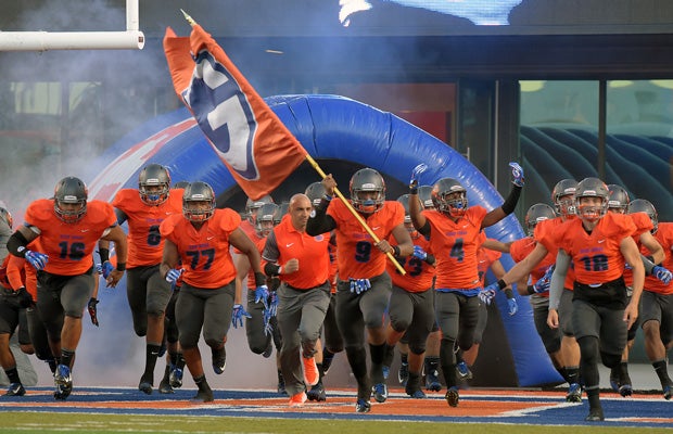 Bishop Gorman head coach Kenny Sanchez and his players rush onto the field for their home opener Friday night.