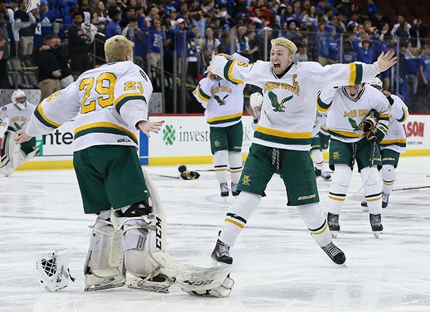 James Betz (right) of Morris Knolls (N.J.) celebrates with goalie Elliot Marken after defeating Monclair in overtime to win the NJSIAA Group A state championship at the Prudential Center.