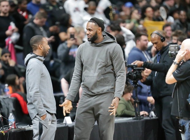 LeBron James talks to his former high school teammate prior to Sierra Canyon's game against his alma mater St. Vincent-St. Mary in 2019.