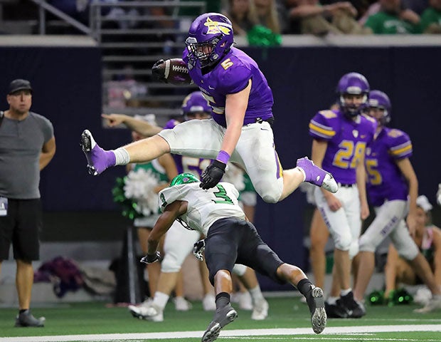 Tallyn Welborn of Sanger (Texas) hurdles an Iowa Park defender during a UIL 4A Division 2 Bi-District playoff game at The Star in Frisco.