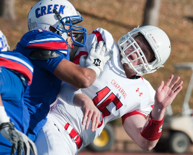 Chaparral (Colo.) quarterback Kyle Gallup takes a hit from a Cherry Creek defender after throwing a pass in a CHSAA 5A playoff game.