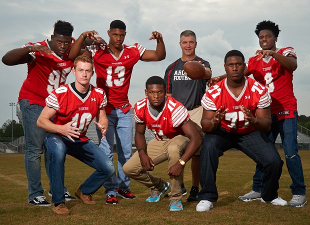 Archer head coach Andy Dyer poses along with six of his top players during a photo shoot in May at the school's football stadium.