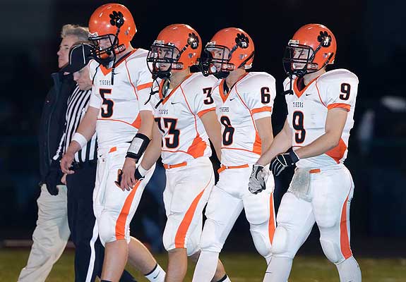 The Tigers and head coach Ron Muhitch take the field before the 7A semifinal against Belleville East.
