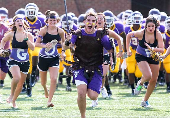 The Trojans are led onto the field before their season-opener against South Pointe.