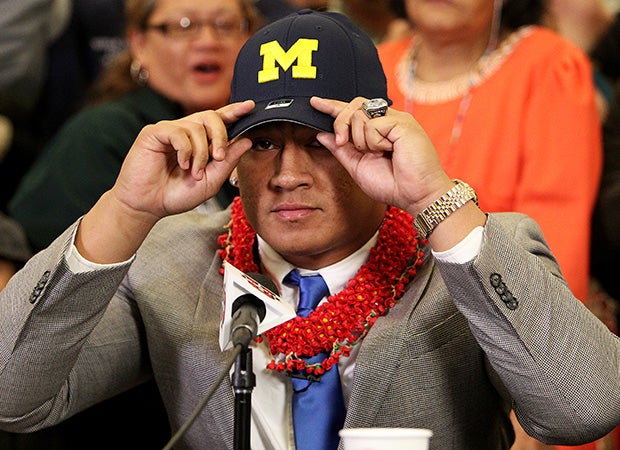 Devin Asiasi makes his college choice known by putting on a Michigan hat.