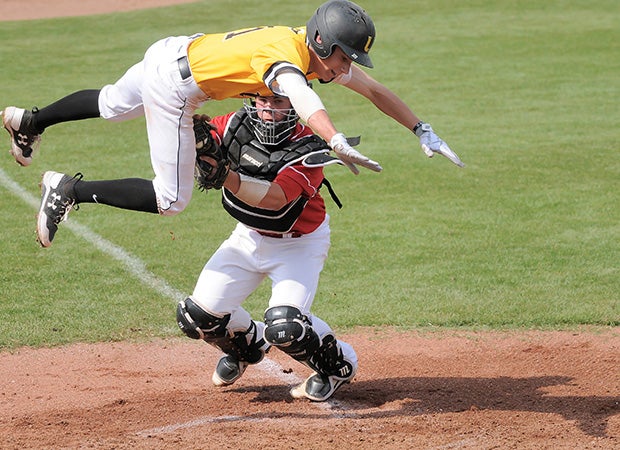 William Safford of University Lab (Baton Rouge, La.) leaps over an Assumption catcher in an attempt to avoid being tagged out at the plate during a game in the ACHS Tournament in Louisiana.