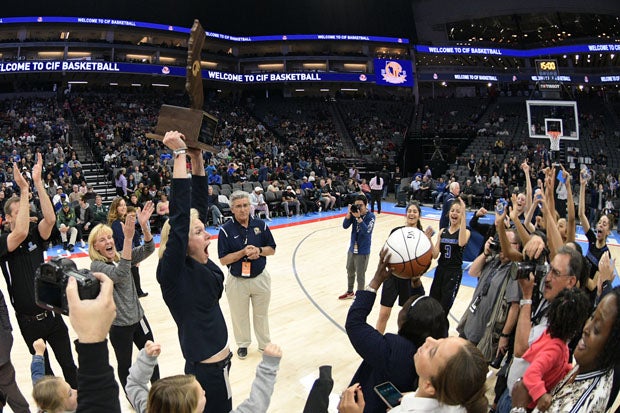 Windward coach Vanessa Nygaard, a former Stanford standout, holds up the trophy after an impressive win over Pinewood.