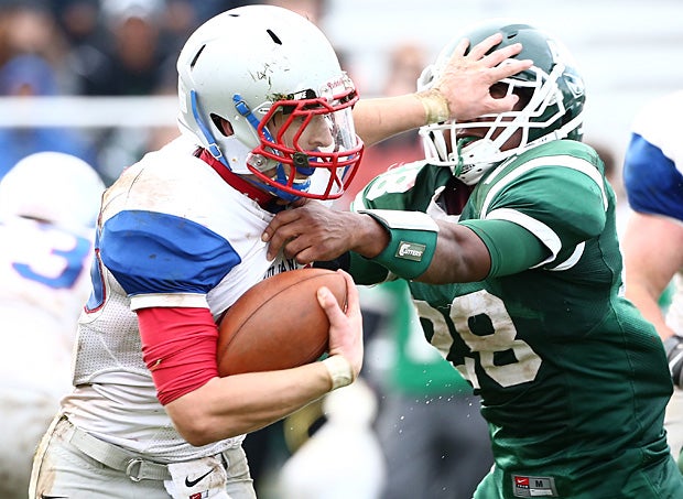 A Tolland (Conn.) rusher stiff arms a Northwest Catholic (West Hartford, Conn.) defender.