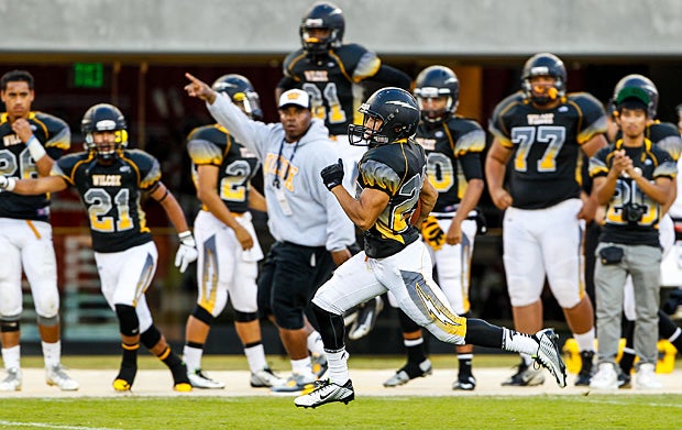Teammates cheer on a Wilcox (Santa Clara, Calif.) player as he runs towards the end zone in a game against Santa Clara (Calif.).