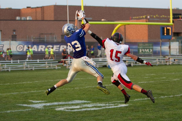 Junior receiver Hayden Nieuwlandt (83) symbolizes Carroll's 8-0 start by grabbing a 50-50 pass. The Chargers, the MaxPreps Indiana Team of the Week, have won five games by a touchdown or less. 