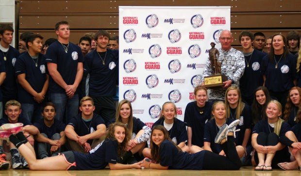 Coach Mark Sims holds the National Guard Fitness for Life trophy.