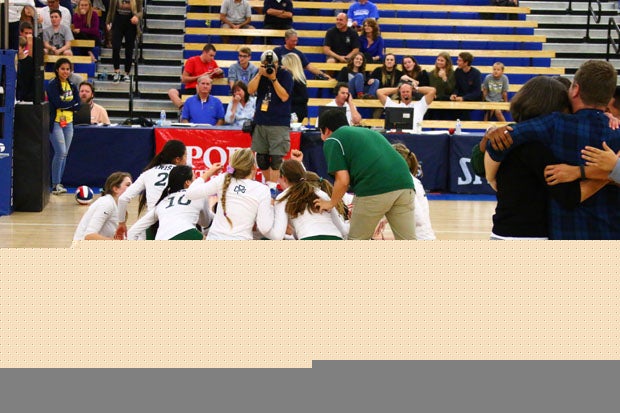 The coaching staff of five enjoy a group hug while the Sacred Heart Cathedral team celebrates on the court after its first state Division III title at Santiago Canyon College in Orange County.