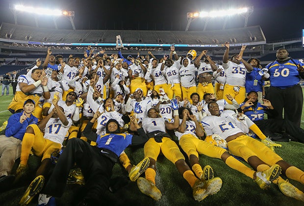 Northwestern players and coaches celebrate by hoisting the championship trophy.