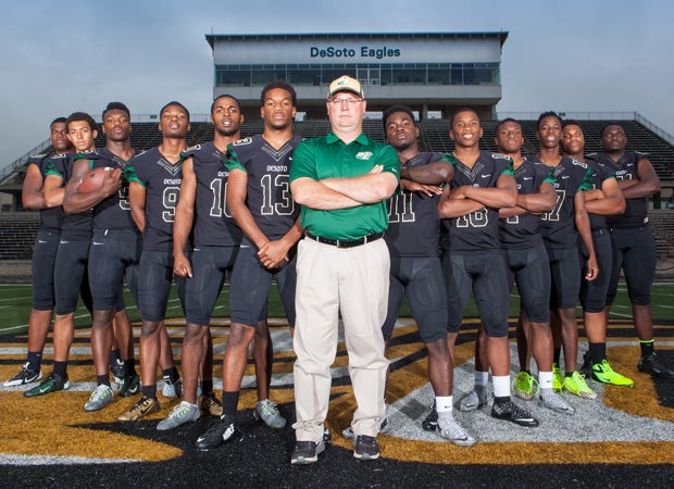 DeSoto head coach Todd Peterman poses with 12 of his top players during a photo shoot held on campus in May.