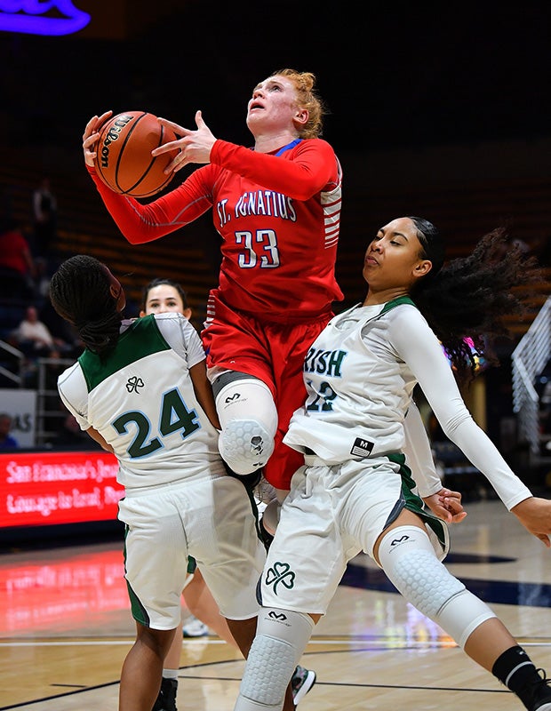 Forward Madelene Ennis of St. Ignatius (Calif.) splits two Sacred Heart Cathedral Preparatory defenders while driving to the basket during at Hass Pavilion in Berekley.