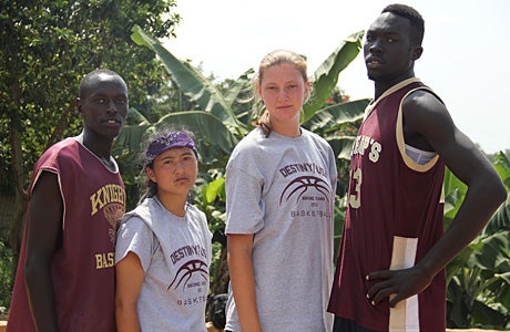 Melissa Peng (left) and Devon Roeper stand between two Ugandan players.