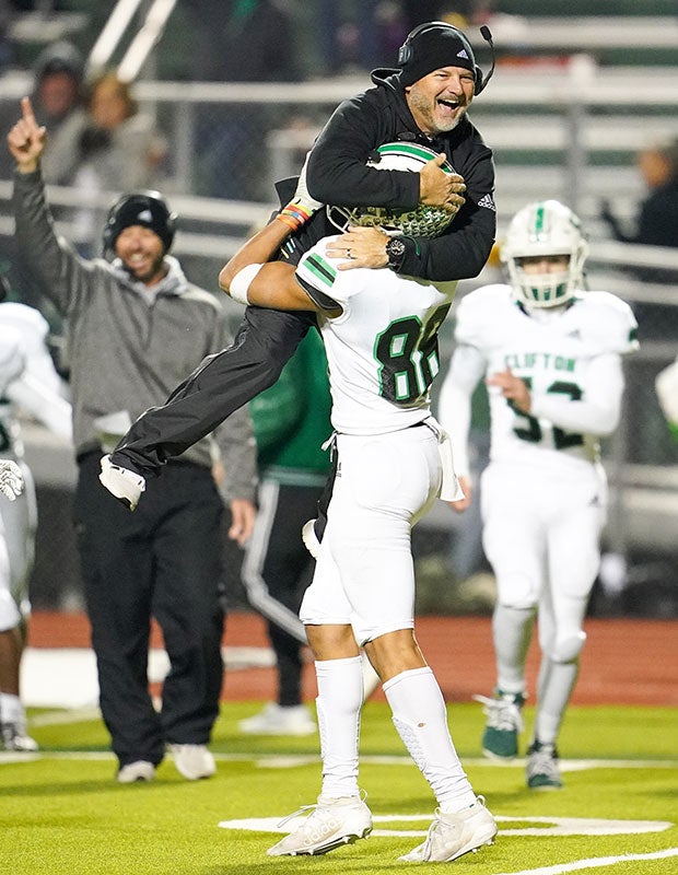 Clifton (Texas) head coach Chuck Caniford jumps into the arms of player TJ Ferch while celebrating during their UIL 3A Division 2 Region II Bi-District playoff game.