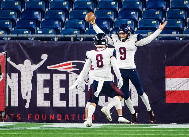Will Vincent (9) of Dexter Southfield (MA) does his best impression of a player featured on a banner in the background while celebrating a touchdown with teammate Jack Mullaney during the NEPSAC Dave Coratti Bowl at Gillete Stadium.