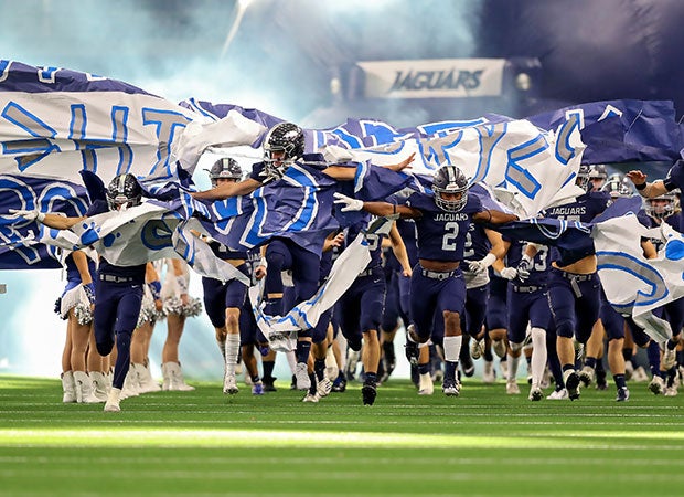 Flower Mound (Texas) players burst through their banner before the kick off of UIL 6A Division 1 Region I Area playoff game at AT&T Stadium. 