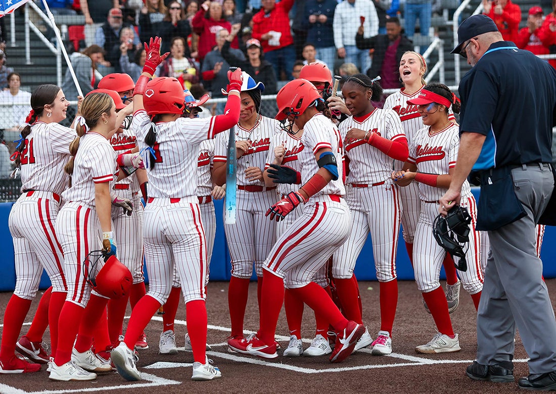 Melissa junior Kennedy Bradley is greeted by her teammates after hitting a grand slam in the Cardinals' 10-0 win over Wakeland in the second round of the Class 5A Division 1 playoffs last week. (PHOTO: Michael Horbovetz)