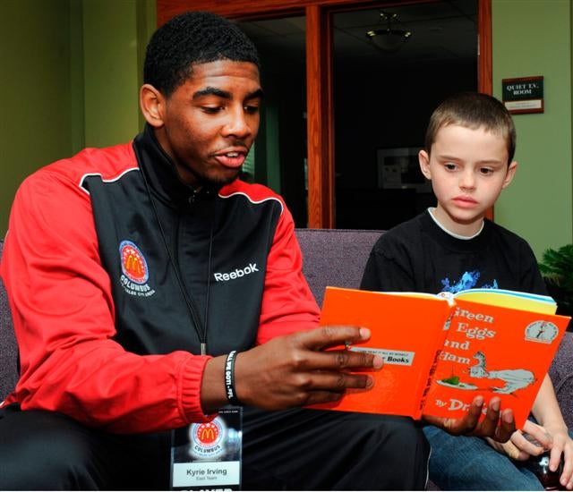 The East's Kyrie Irving reads to a lad at RMHC of Central Ohio.