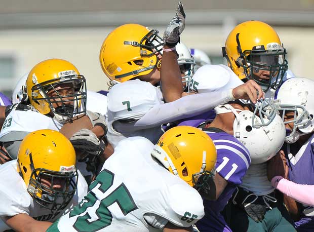Kennedy (Sacramento, Calif.) JV players (in white) barrel through players from Sacramento (Calif.).