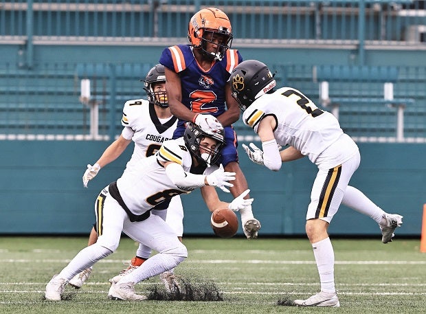 A Rochester Prep receiver tries to secure the catch between a trio of Honeoye Falls-Lima defenders. (Photo: James Lathrop)