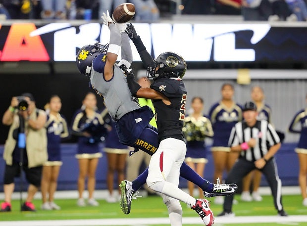 Jordan Ross of Warren makes a reception over Anthony Francis of Downey. (Photo: Rene Morales)