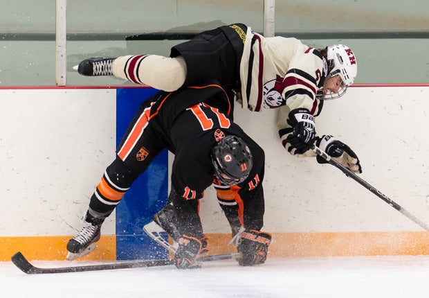 Kimball Union Academy's Alex Heinritz (11) hip checks Kents Hill School's Felix Beaulieu along the boards during the Joshua H. Weeks New Year's Tournament in Massachusetts.