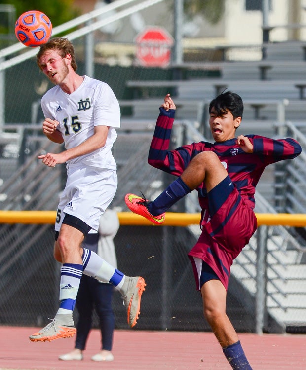 Paul Fitzpatrick of Desert Vista (Ariz.) leaps for a header in front of a Perry player.