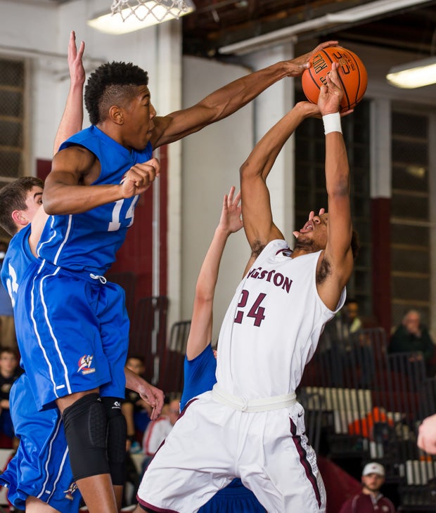 Washingtonville (N.Y.) guard Nick Arthur blocks a shot by Kingston's Andrai Bailey.
