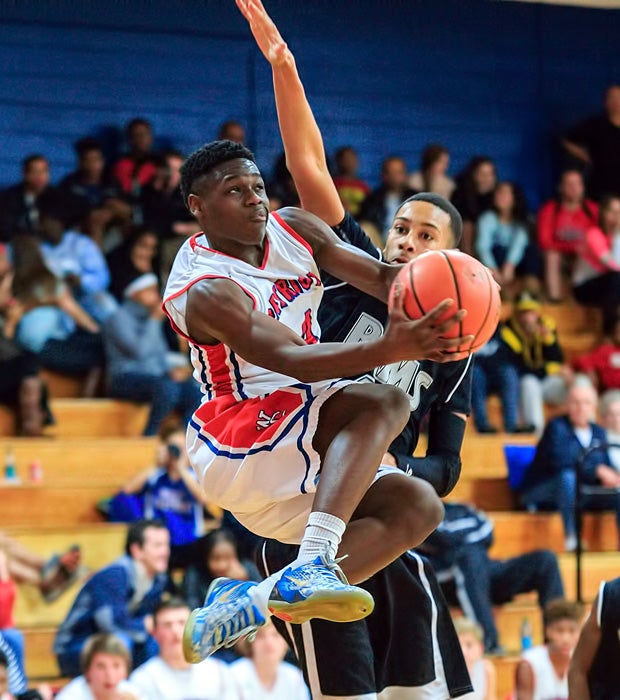 A West Carteret (N.C.) junior varsity player flies under a Havelock defender while scoring a basket.