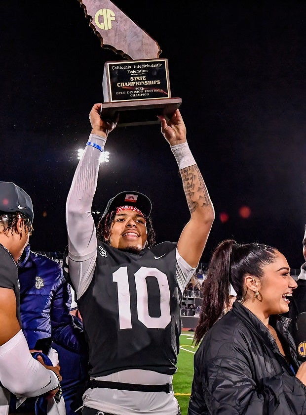 St. John Bosco quarterback Pierce Clarkson holds the CIF Open Division trophy high after the Braves' 45-0 win over Serra on Saturday at Saddleback College. (Photo: Louis Lopez)