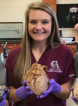 Young, holding a human heart, has an interest in the
medical field after high school.