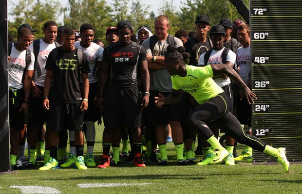 Players look on as Tony Brown, of Ozen (Beaumont, Texas), competes in the agility shuffle during the SPARQ finals.