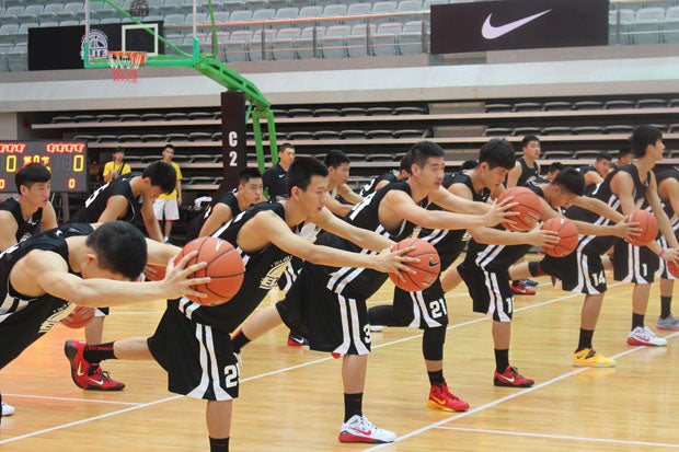 Players from the Nike High School Elite Camp in Shanghai, China, stretch before another day of elite training from three American high school coaches. 