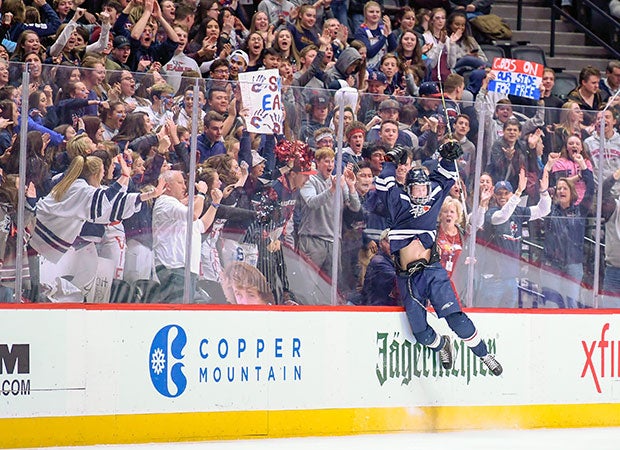 Drew Eichelman of Dakota Ridge (Colo.) leaps against the boards while celebrating his second-period, game-tying goal in the CHSAA 5A state championship game against Regis Jesuit.