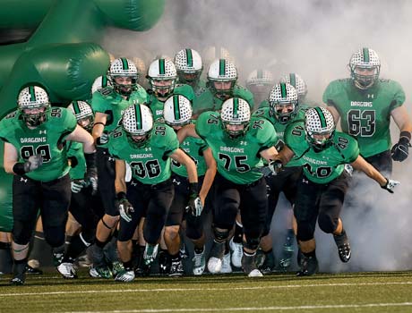 Carroll players rush onto the field during pregame introductions Saturday night. 