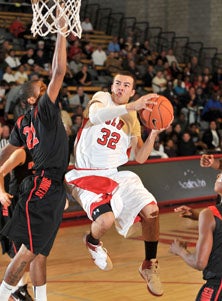 Orange Lutheran's Gabe York hangs
in for two of his 25 points. 