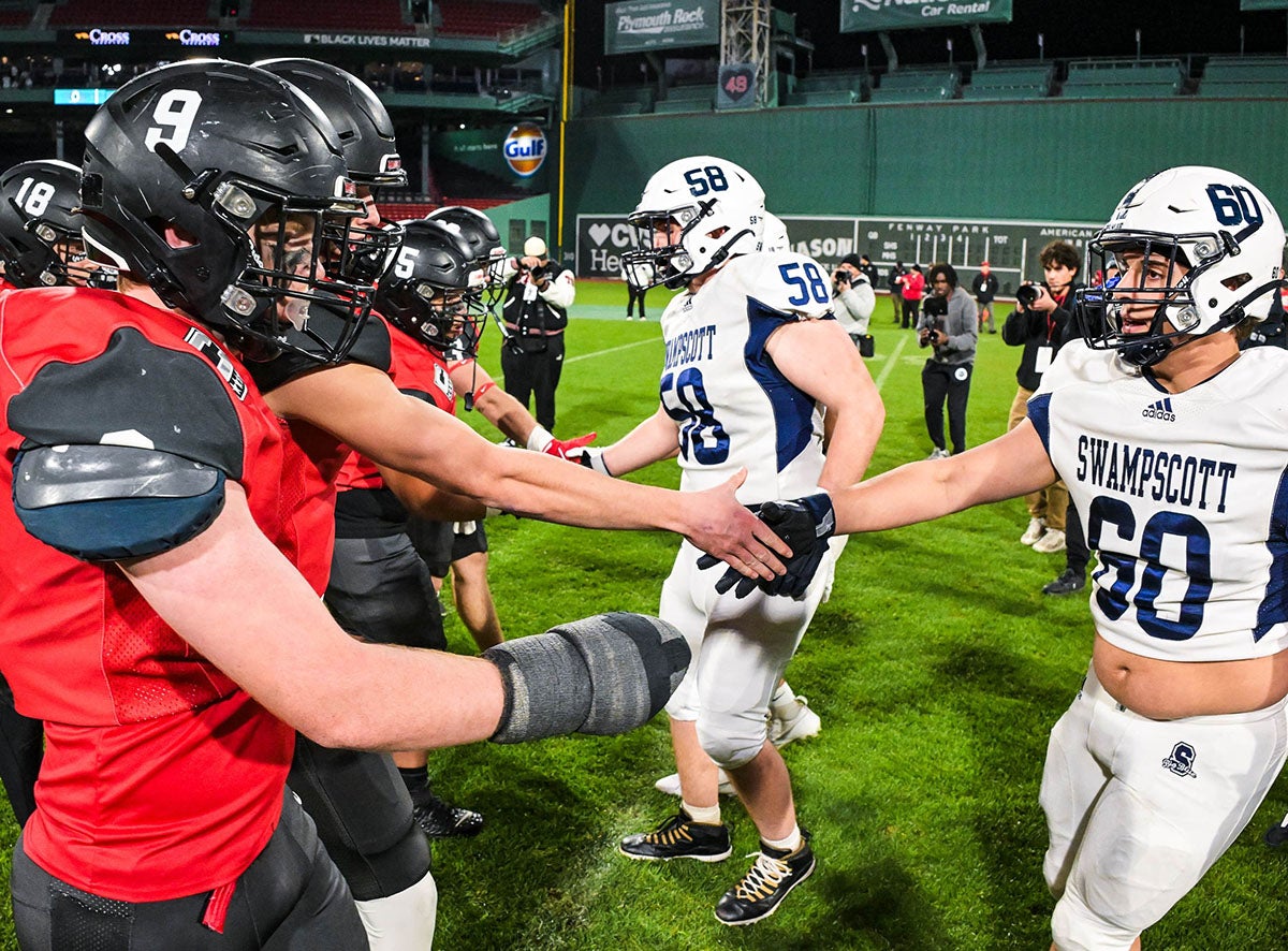 Marblehead and Swampscott captains meet on the field under the Green Monster for the coin toss. Marblehead won the game 42-6. (Photo: Mike Braca)