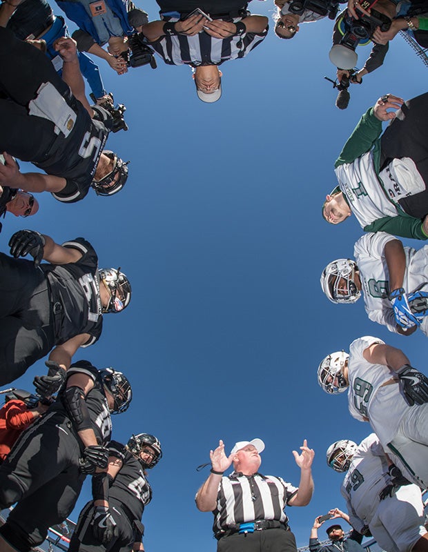 Pueblo South (Colo.) and Pine Creek captains receive their pre-game instructions from an official before the CHSAA 4A state championship game at Sports Authority Field in Denver. 