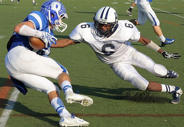 Rod-Djoly Thorby of Wilton (Conn.) attempts to make the tackle on a cutting Darien (Conn.) ball carrier.