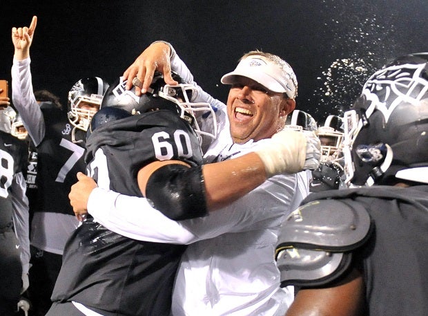 St. John Bosco coach Jason Negro celebrates with a player after the Braves' CIF Open Division win over De La Salle on Saturday.