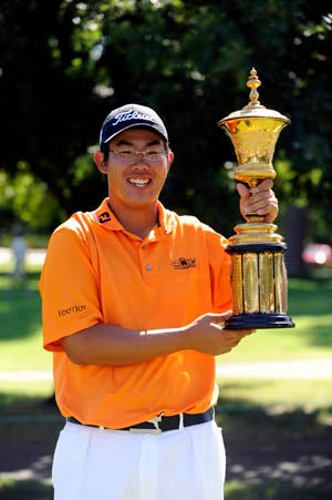 An holds up trophy after winning the U.S. Amateur.