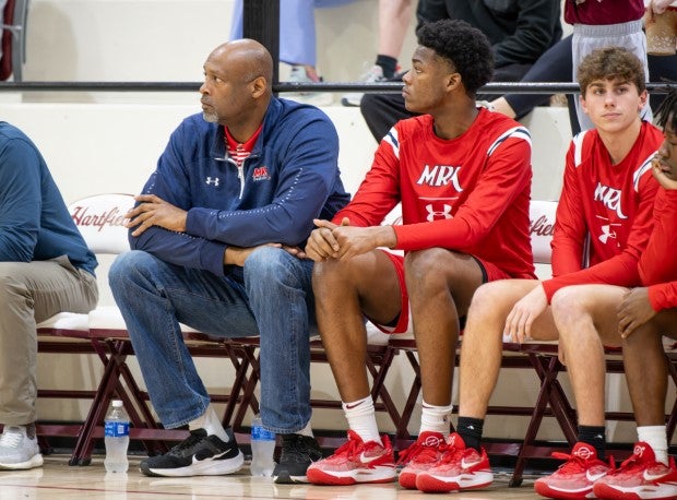 Erick Dampier Jr. sits on the bench next his father, who is an assistant coach at Madison-Ridgeland Academy. (Photo: Brad Bridges)