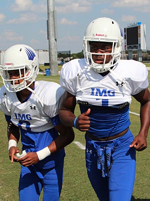 K.J. Osborn (middle) runs alongside teammate Sean
Daniel (left) during spring practice at IMG Academy.