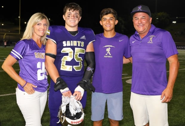 Connor Heffler – pictured with his family after a Sept. 6 win over Loyola – raised more money to fight childhood cancer than any other high school football player in the country.